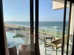 Porto Said Resort Chalet في بورسعيد: شرفة مع طاولة وكراسي والمحيط