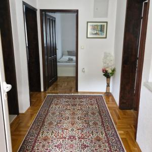 um corredor com um tapete num piso de madeira e uma porta em Guest house Mostar em Mostar