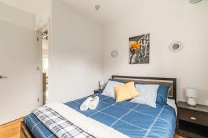 a bedroom with a blue bed with two pillows at Modern 2 BR Condo - Heart of Leslieville in Toronto