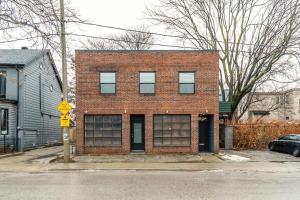 a red brick building on the corner of a street at Modern 2 BR Condo - Heart of Leslieville in Toronto