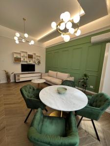 a living room with a table and green chairs at PoshSpot Apartments in Cluj-Napoca