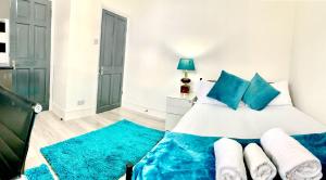 - une chambre avec un grand lit et des oreillers bleus dans l'établissement Sandra Stay MP, à Londres