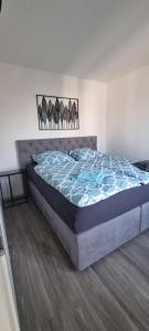Bett in einem Schlafzimmer mit blauer Decke in der Unterkunft Stilvoll und modern in Weyhausen