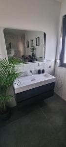 a bathroom with a sink and a large mirror at Stilvoll und modern in Weyhausen
