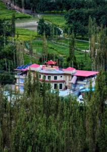 una casa con techo rojo en una colina en POLO LAND HOTEL Skardu, en Tandal