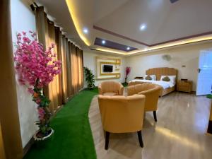 um quarto de hotel com uma cama, cadeiras e flores em POLO LAND HOTEL Skardu em Tandal