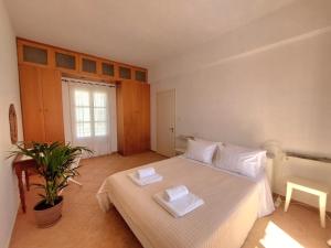 een slaapkamer met een bed met twee handdoeken erop bij ASIA in Ermoupoli