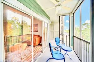 balcón con sillas azules y cama en 3BR Condo with Hot Tub and Pool - Near Disney en Orlando