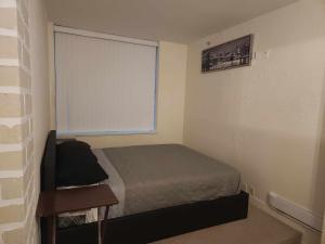 a small bedroom with a bed and a window at Modern Townhouse in Vancouvers Vibrant Heart in Vancouver