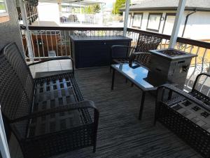 balcón con sillas, mesa y parrilla en City Charm: Furnished 3-BR Retreat en Vancouver