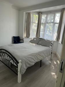 1 cama blanca en un dormitorio con ventanas en A cosy 8 Bedroom House en Edmonton
