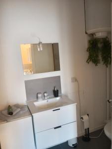 y baño con lavabo blanco y espejo. en Studio de 14m2 dans une maison, en Cagnes-sur-Mer