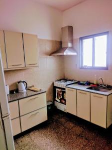 a kitchen with white cabinets and a stove and a window at G Duplex estratégico en ciudad de Mendoza in Mendoza