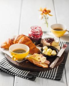 a plate of food with bread and two cups of coffee at Onix H in Ksamil