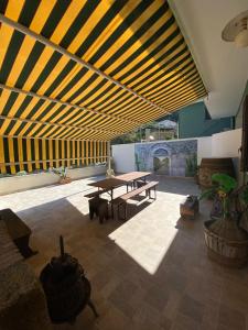 a patio with a picnic table and a wooden ceiling at La Badia in Messina