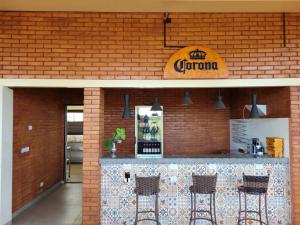 un restaurante con un mostrador con tres taburetes en Bee Cool Hostel en Palmas