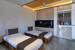 2 camas en una habitación con cocina en OYO Flagship Welcome Premium en Khandagiri