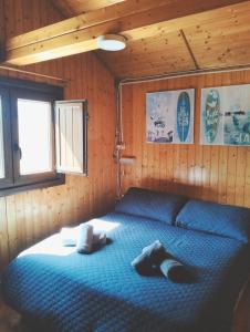 ein Schlafzimmer mit einem blauen Bett in einer Hütte in der Unterkunft Cabaña in Rubayo