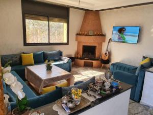 sala de estar con sofás azules y chimenea en Ferme benchriyette, en Cité de Bournazel