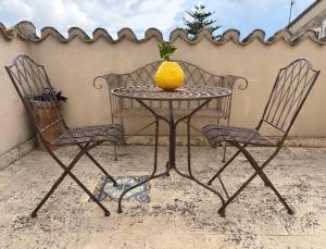 un tavolo e due sedie con sopra un ananas di Palazzo Candida B&B a Gerace
