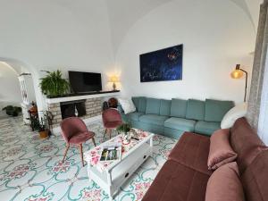 uma sala de estar com um sofá azul e cadeiras em Villa Azul em Anacapri