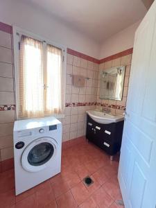 y baño con lavadora y lavamanos. en KAZARMA Luxury House, en Pilikáta