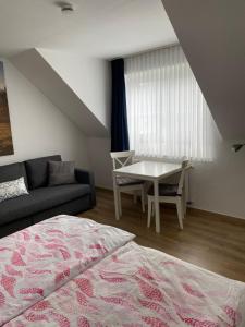 a bedroom with a bed and a table and a couch at Ferienhof Kröger in Bielefeld