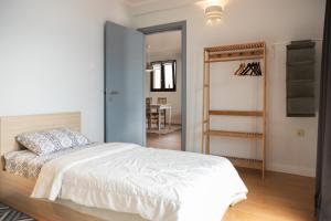 a bedroom with a white bed and a hallway at Apartments Djurovic in Kotor