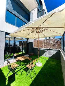 圣塞巴斯蒂安德洛斯雷耶斯Loft 29 con piscina, terraza, jardín y Netflix的带桌椅和遮阳伞的露台