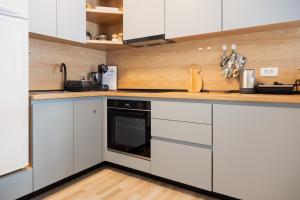 a kitchen with white cabinets and a dishwasher at Apartments Djurovic in Kotor