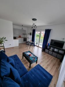 uma sala de estar com um sofá azul e uma mesa em Apartament Nad Wisłą em Tczew