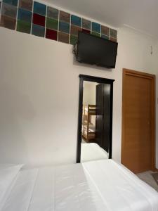 1 dormitorio con 1 cama y TV de pantalla plana en la pared en Scalo 71 GUEST HOUSE en Roma