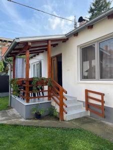 una piccola casa bianca con portico e scale di Rustic Villa a Jagodina