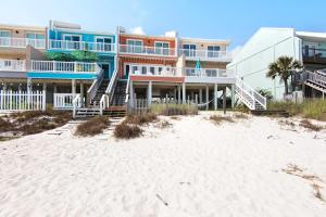 a building on the beach next to a sandy beach at Life's A Beach Townhouse in Navarre