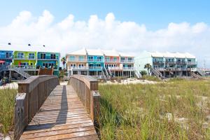 a wooden bridge over a beach with houses at Life's A Beach Townhouse in Navarre