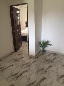 una camera con pavimento in marmo e porta con pianta di Serengeti Rest Lodge ad Afienya