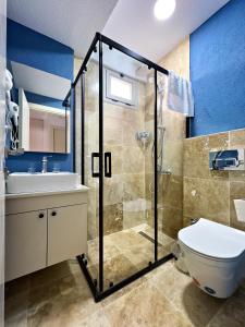 a bathroom with a shower and a toilet and a sink at Nese Pension in Bodrum City