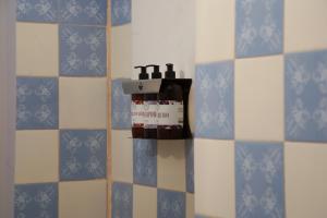 a soap dispenser in a bathroom with blue and white tiles at ISONDU Suites & Breakfast in Puerto Iguazú