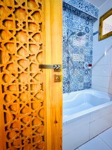 a bathroom with a wooden door and a tub at Dar Lina Guesthouse Luxor in Luxor