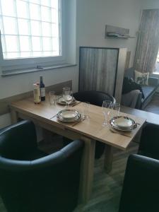 溫特貝格的住宿－Ferienwohnung Sauerland，一张木桌,上面放有盘子和酒杯