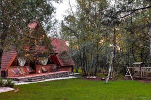 a house with a red roof in a yard at Chalet privado en el bosque con Jacuzzi de Madera Huasca Retreats in Huasca de Ocampo