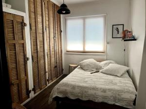 a small bedroom with a bed with a window at La campagne a la mer sur la cote bleue in Martigues
