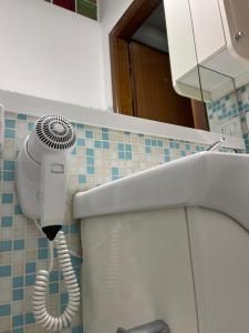 a bathroom with a blow dryer next to a toilet at Scalo 71 GUEST HOUSE in Rome