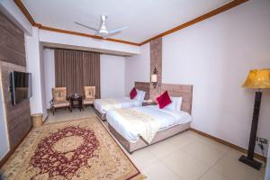 Habitación de hotel con 2 camas y TV en Shelton's Rezidor Hotel, en Peshawar