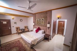 sypialnia z łóżkiem, stołem i krzesłami w obiekcie Shelton's Rezidor Peshawar w mieście Peszawar