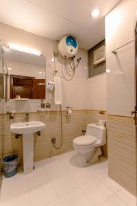 a bathroom with a toilet and a sink and a shower at Shelton's Rezidor Peshawar in Peshawar