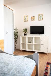 a bedroom with a white entertainment center with a television at Pensjonat Kaja in Rymanów-Zdrój