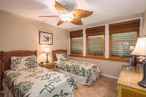 a bedroom with two beds and a ceiling fan at Hale Hui Kai 106 - Newly Renovated, Split AC in Wailea