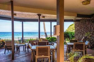 a restaurant with tables and chairs and a view of the ocean at Hale Hui Kai 106 - Newly Renovated, Split AC in Wailea
