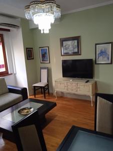 Nikolic Apartments - Ohrid City Centre في أوخريد: غرفة معيشة مع تلفزيون وطاولة